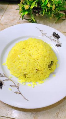 Mute vertical clip: steaming Bengali khichuri on a plate; an egg fry and a small serving of pickle are added. Clean food styling for recipe intros, reels, shorts and cooking projects.