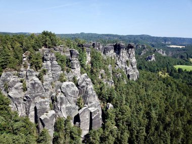 Sakson İsviçre Ulusal Parkı 'ndaki mavi gökyüzünün altında Elbe Kum Taşı Dağları' nın üstünden çekilen insansız hava aracı fotoğrafı.