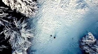 Kar manzarasının üzerinde uçan sakin bir drone videosu.