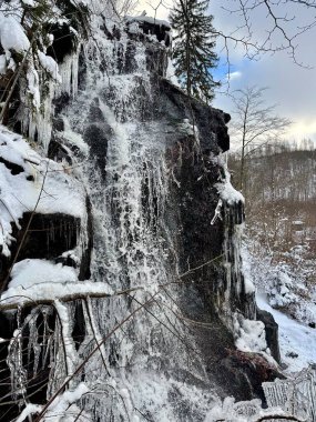 Almanya 'nın bir yanından Harz Dağları' nda kışın oluşan bir arazide şelale.