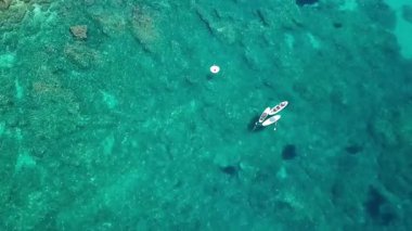 Dobra Voda Karadağ 'daki turkuaz sularda sörf tahtaları bulunan güzel Akdeniz' in yukarısından bir insansız hava aracı videosu
