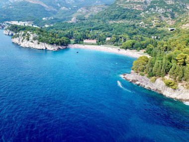Miloc sahilinin insansız hava aracı fotoğrafı ve Sveti Stefan Montenegro 'nun küçük körfezindeki mavi deniz suyu.