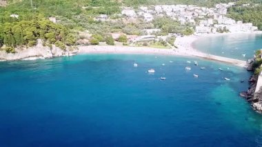 Koyun kumsalının güzel mavi suyu ve Karadağ 'daki Sveti Stefan adasının insansız hava aracı videosu.