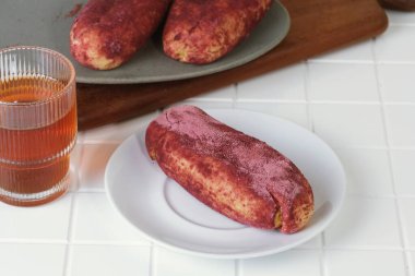 Beyaz tabakta servis edilen Goguma Ppang adlı Kore tatlı patates ekmeği..