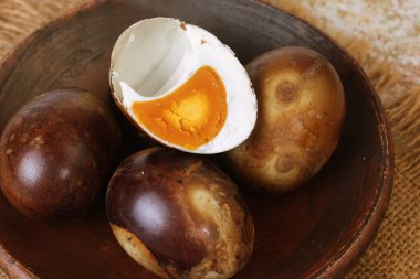 Geleneksel ızgara tuzlu yumurta kahverengi kabuklu ve kırsal yüzeyinde turuncu sarısı var..