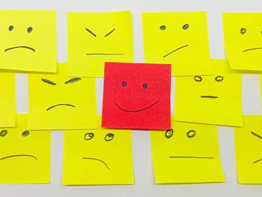 birden fazla yüzleri ve bir gülümseme ile öne çıkan küçük ofis notları ile olumlu bir tutum için kavram