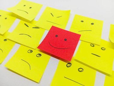 birden fazla yüzleri ve bir gülümseme ile öne çıkan küçük ofis notları ile olumlu bir tutum için kavram