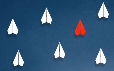 Beyaz kağıt uçaklar arasında cesurca uçan yenilikleri sembolize eden kırmızı kağıt bir uçak resmi..