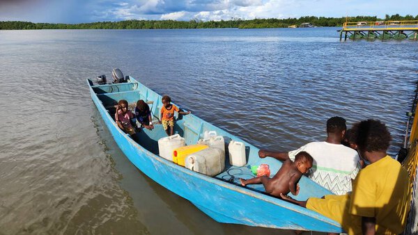 Papuan locals cross the sea in a wooden boat near coastal Papua, Indonesia. Daily transportation between islands. Captured on June 28, 2025.  Papua, Indonesia