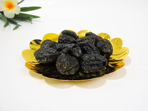 Parlak altın bir tabağa yerleştirilmiş Ajwa ağaçları, besin değeri yüksek sağlıklı meyveler, genellikle Ramazan 'da keyif alırlar..