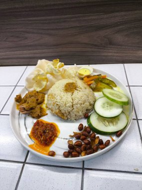 Tarafsız bir zeminde sebze, mercimek, fıstık, salatalık dilimleri ve çıtır çıtır atıştırmalıklarla çevrili beyaz pirinçli bir tabak yemek ve mutfak pazarlama için mükemmel bir ev yapımı ve davetkar atmosferi çağrıştırıyor..