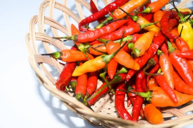 Beyaz arka planda sepetteki kırmızı biber.