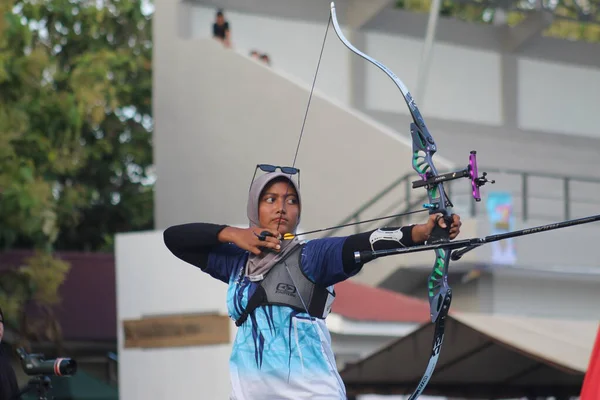 Banda Aceh, Indonesia - September 16, 2025: Determined female archer wearing sports hijab and protective gear