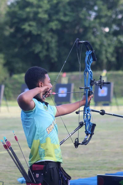 Banda Aceh, Indonesia - September 21, 2025: The athlete is captured in perfect shooting form, with arrows in the quiver and target boards visible in the background