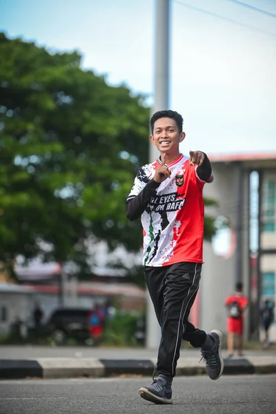 Banda Aceh, Endonezya - 25 Eylül 2025: Kameraya doğru koşarken gülümseyen genç adam