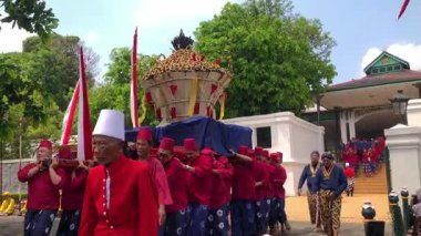 Jogja - 5 Eylül 2025. Jogjakarta Sarayı 'ndan Abdi Dalem, Dal Yılı' ndaki Grebeg Maulud Seremonisi sırasında silah taşıyarak saraydan Yogyakarta Sarayı 'nın Gedhe Camii' ne yürüdü.