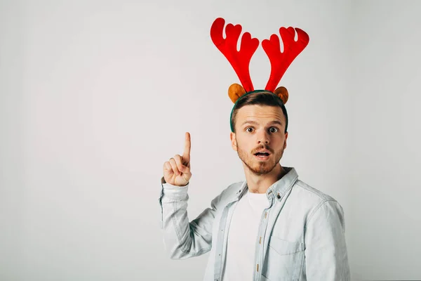 surprised man in red christmas hat over grey background