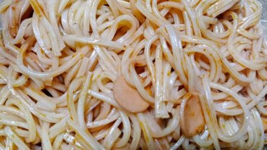 Hafif soslu soslu soslu spagetti eriştesi. Makarna cam bir kasede servis ediliyor. Karışık erişte ve malzemelerin dokusunu gösteriyor..