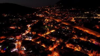 Stunning drone footage of Kalkan, Turkey at night. Capture the charming coastal town illuminated by city lights