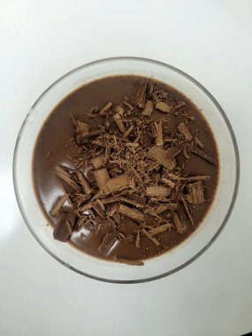 Genel bir bakış açısında, cam bir kasede çikolatalı puding sergileniyor, koyu çikolata parçacıklarıyla süslenmiş. Bu zengin ve çökmüş ziyafet tatlı bir hoşgörü için mükemmel..