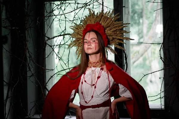 Çarpıcı bir başlık ve yüz boyasıyla süslenmiş geleneksel Ukrayna kıyafeti içindeki bir kadının büyüleyici portresi, bir pencere zeminine kültürel miras ve mistik bir duyguyu anımsatıyor. 