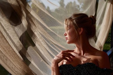A woman standing in front of a curtain