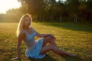 A woman sitting on grass in a park