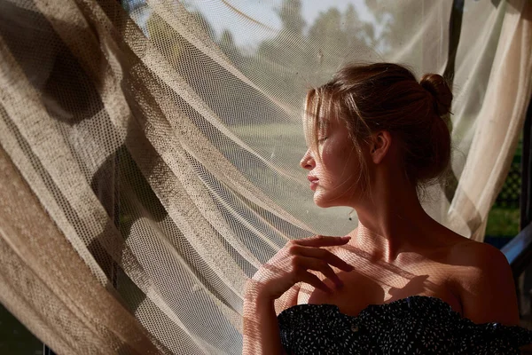 A woman standing in front of a curtain