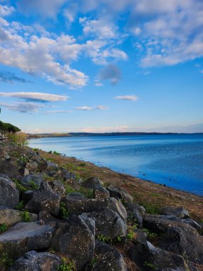 Rocky coastline with waves and a dramatic cloudy sky.