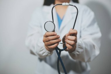 Elinde steteskop tutan genç bir erkek doktor.