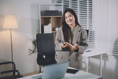 Ofiste duran genç İspanyol profesyonel iş kadınının portresi. Mutlu kadın şirket yöneticisi, gülümseyen iş kadını şirket yöneticisi tablet kullanarak kameraya bakıyor.