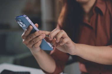 Ofiste cep telefonu kullanan bir iş kadınının yakın plan görüntüsü