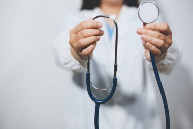 Elinde steteskop tutan genç bir erkek doktor.