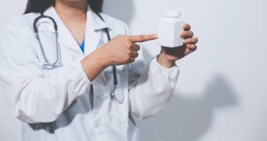 Tedavi için ilaç ya da ilaç tutan doktor ya da eczacı. Şişede antibiyotik hap var..