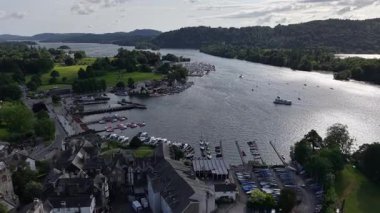 Stunning aerial perspective of Windermere Lake showcasing a vibrant boating area. Lush greenery surrounds the water while small boats glide across the lake on a sunny afternoon.