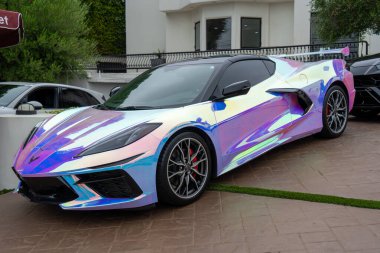 Yanardöner bir Chevrolet Corvette C8 Stingray araba yoluna park etmiş. Eşsiz inci aromalı boya..