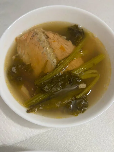 Yapraklı sebzeli bir kase somon çorbası. Hafif çorba, basit bir sunum..