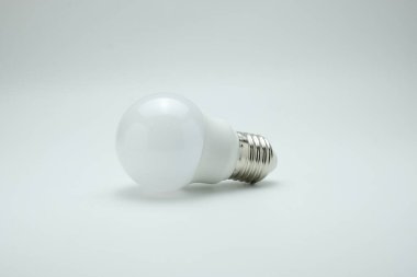 Temiz ve minimal arkaplana yerleştirilmiş modern beyaz bir LED ampul. Enerji verimliliği, teknoloji, yenilik, sürdürülebilirlik ve parlak fikirler için uygundur.