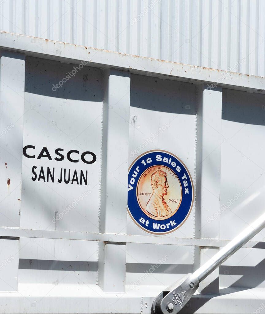 03/11/2018 - Puerto Rico, USA: White cargo truck in San Juan, showing a printed location label and a circular emblem with a penny graphic referencing a one-cent sales tax program.