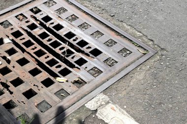 Yağmur suyu veya drenaj için giriş noktası olarak çalışan yol yüzeyinde delikleri olan metal bir ızgara..