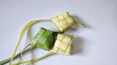 Ketupat (pirinç köftesi), Hindistan cevizi yapraklarından yapılan ve pirinçle doldurulmuş geleneksel bir Endonezya yemeğidir. Bayram kutlamaları için özel bir yemek. Fotoğraf beyaz arkaplanda bir grup ketupatı gösteriyor