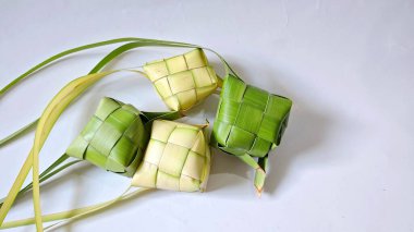 Ketupat (pirinç köftesi), Hindistan cevizi yapraklarından yapılan ve pirinçle doldurulmuş geleneksel bir Endonezya yemeğidir. Bayram kutlamaları için özel bir yemek. Fotoğraf beyaz arkaplanda bir grup ketupatı gösteriyor