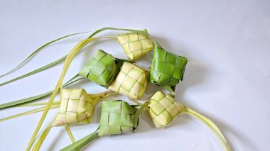 Ketupat (pirinç köftesi), Hindistan cevizi yapraklarından yapılan ve pirinçle doldurulmuş geleneksel bir Endonezya yemeğidir. Bayram kutlamaları için özel bir yemek. Fotoğraf beyaz arkaplanda bir grup ketupatı gösteriyor