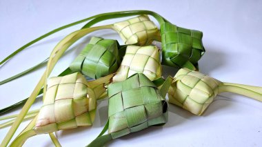 Ketupat (pirinç köftesi), Hindistan cevizi yapraklarından yapılan ve pirinçle doldurulmuş geleneksel bir Endonezya yemeğidir. Bayram kutlamaları için özel bir yemek. Fotoğraf beyaz arkaplanda bir grup ketupatı gösteriyor