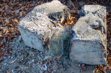 Kıyıda iki büyük tuğla arasında eski bir balıkçı ağı var..