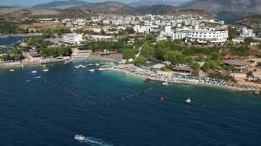 Arnavutluk 'un Ksamil kenti ve plajının insansız hava aracı görüntülerinde kıyı şeridi, tatil beldeleri ve turkuaz su bulunuyor.