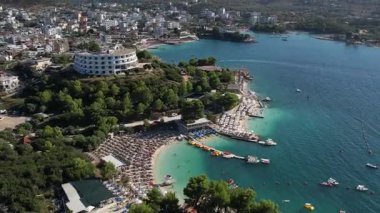 Arnavutluk 'un 4K' lık Ksamil plajı ve kıyı şeridinde turkuaz deniz ve yaz atmosferli İHA görüntüleri.