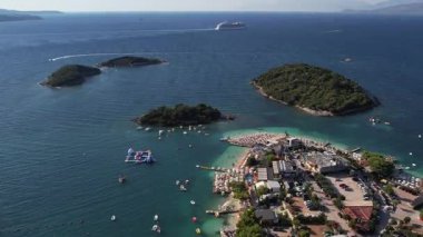 Arnavutluk 'un güneyindeki Ksamil Adaları' nın turkuaz deniz, tekne ve kıyı şeridine ait 4K hava aracı görüntüleri.