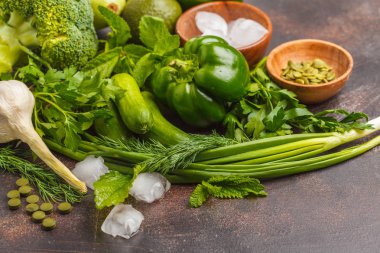 Karanlık bir arka plan üzerinde yeşil sebze. Sebze vejetaryen diyet gıda arka plan: kabak, biber, brokoli, salatalık, avokado, elma, otlar. Sağlıklı yaşam konsepti.