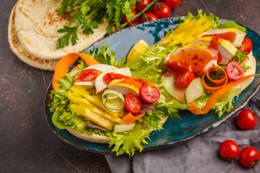 Pide ızgara tavuk, acı sos ve sebze, koyu arka plan ile. Türk kebap, shawarma, Yunan gyros